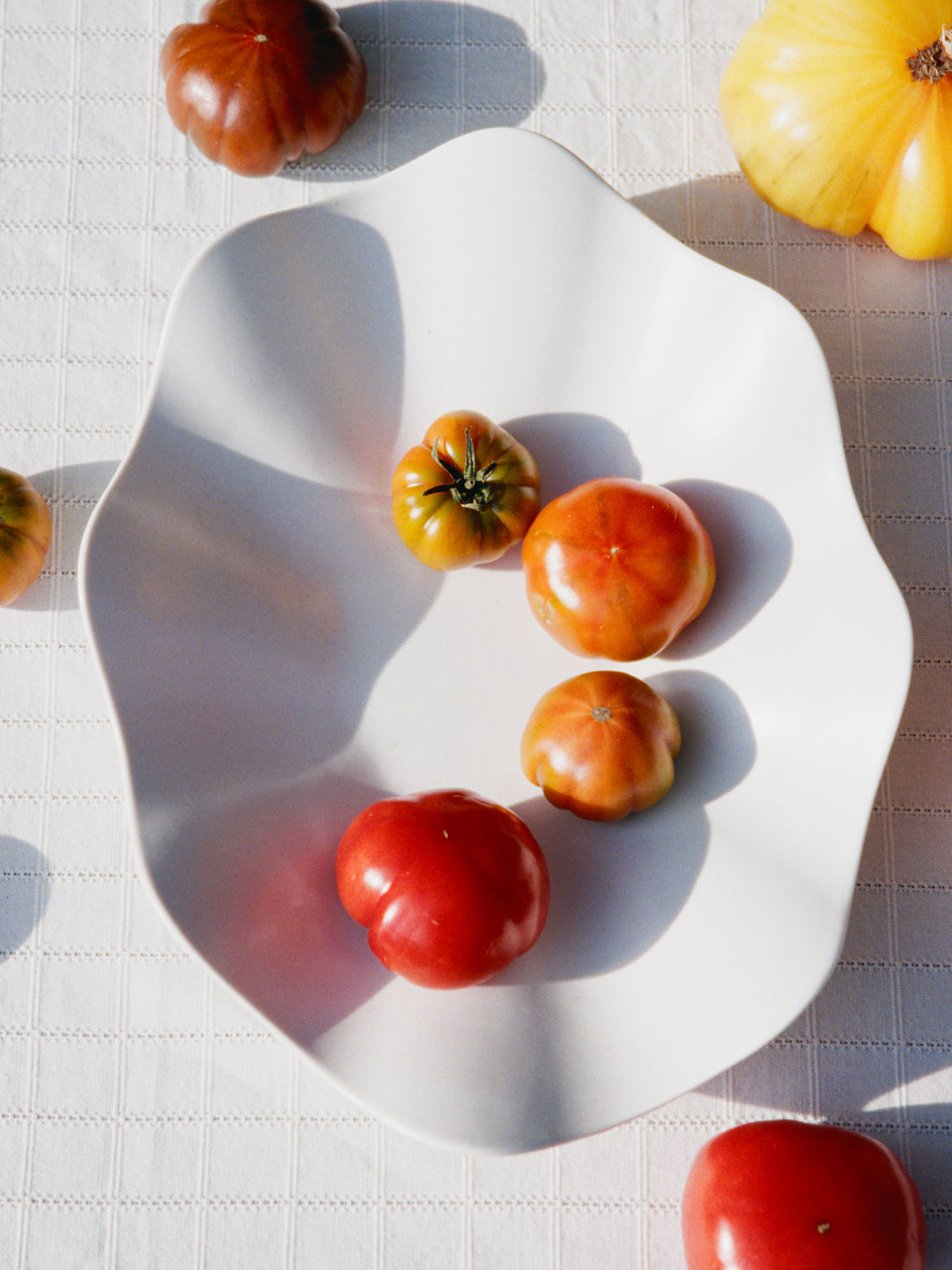 tomatoes on a white ceramic plate from ARKET in natural light