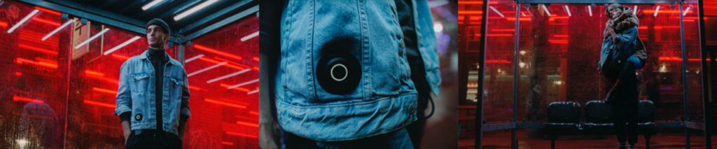 Man standing at a bus stop wearing a denim jacket; close up of the jacket showing a sensor in the jacket pocket; man and woman hugging